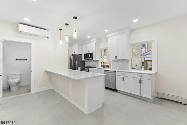 a large white kitchen with a large island oven a sink and appliances