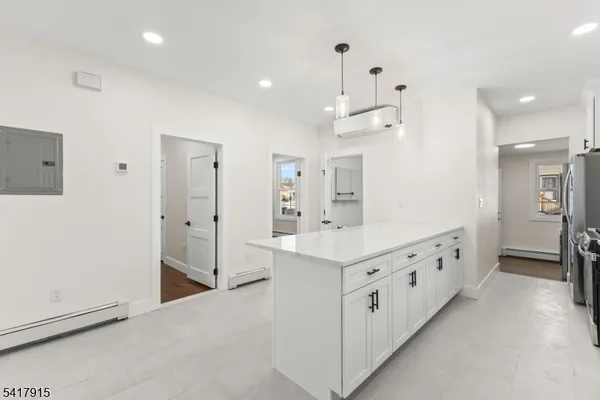 a large white kitchen with kitchen island a sink a stove and a refrigerator