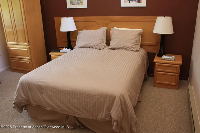 a bed sitting in a bedroom next to a lamp