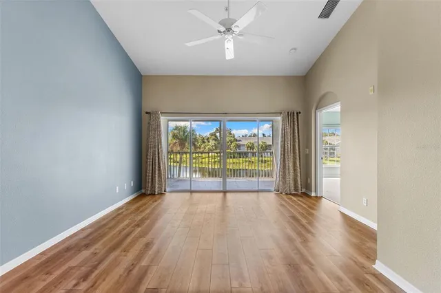 a view of a room with wooden floor and a floor to ceiling window