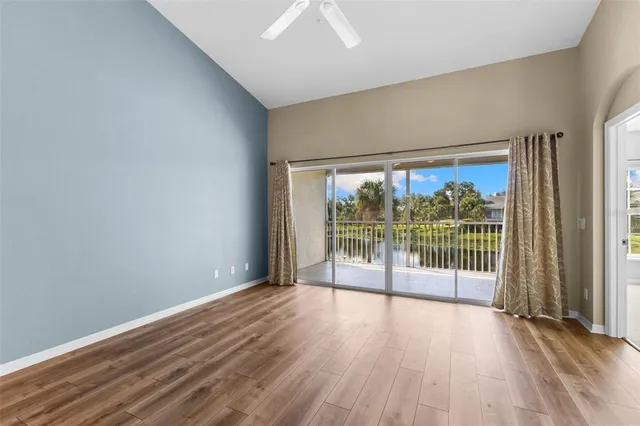 a view of a room with wooden floor and kitchen view