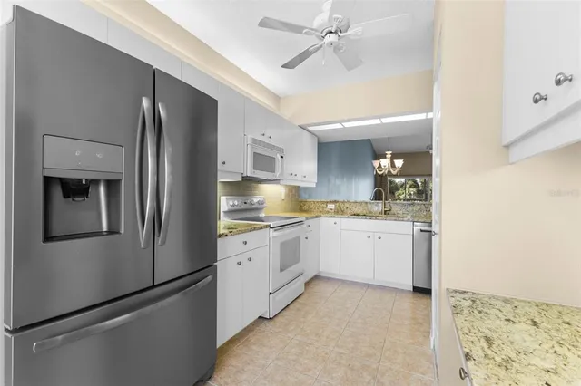 a kitchen with a refrigerator and white cabinets