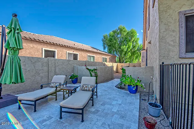 a backyard of a house with table and chairs