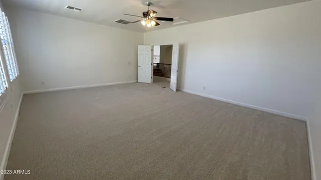 an empty room with a window and a kitchen