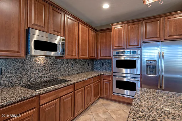 a kitchen with stainless steel appliances granite countertop a stove microwave and refrigerator