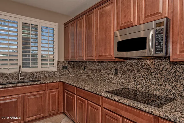 a kitchen with granite countertop cabinets stainless steel appliances a sink and a counter space