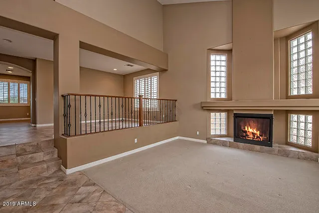 a view of an empty room with a fireplace and a window