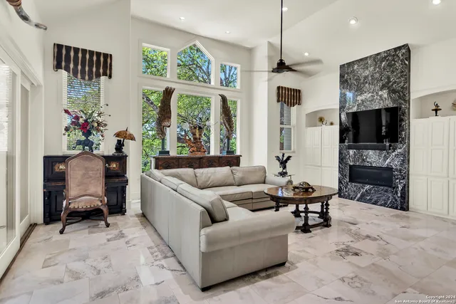 a living room with furniture fireplace and a large window