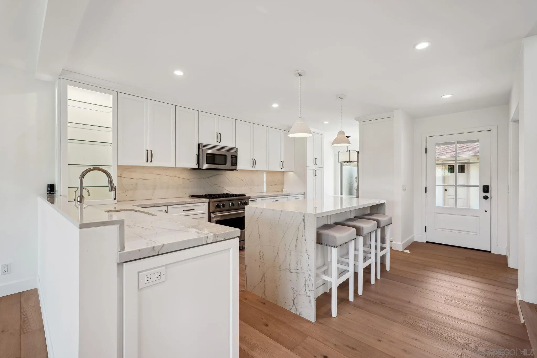 211 Via Osuna Rancho Santa Fe, CA 92091 - Photo 2 of 32 a kitchen with stainless steel appliances granite countertop a refrigerator a stove a sink a dining table and chairs with wooden floor
