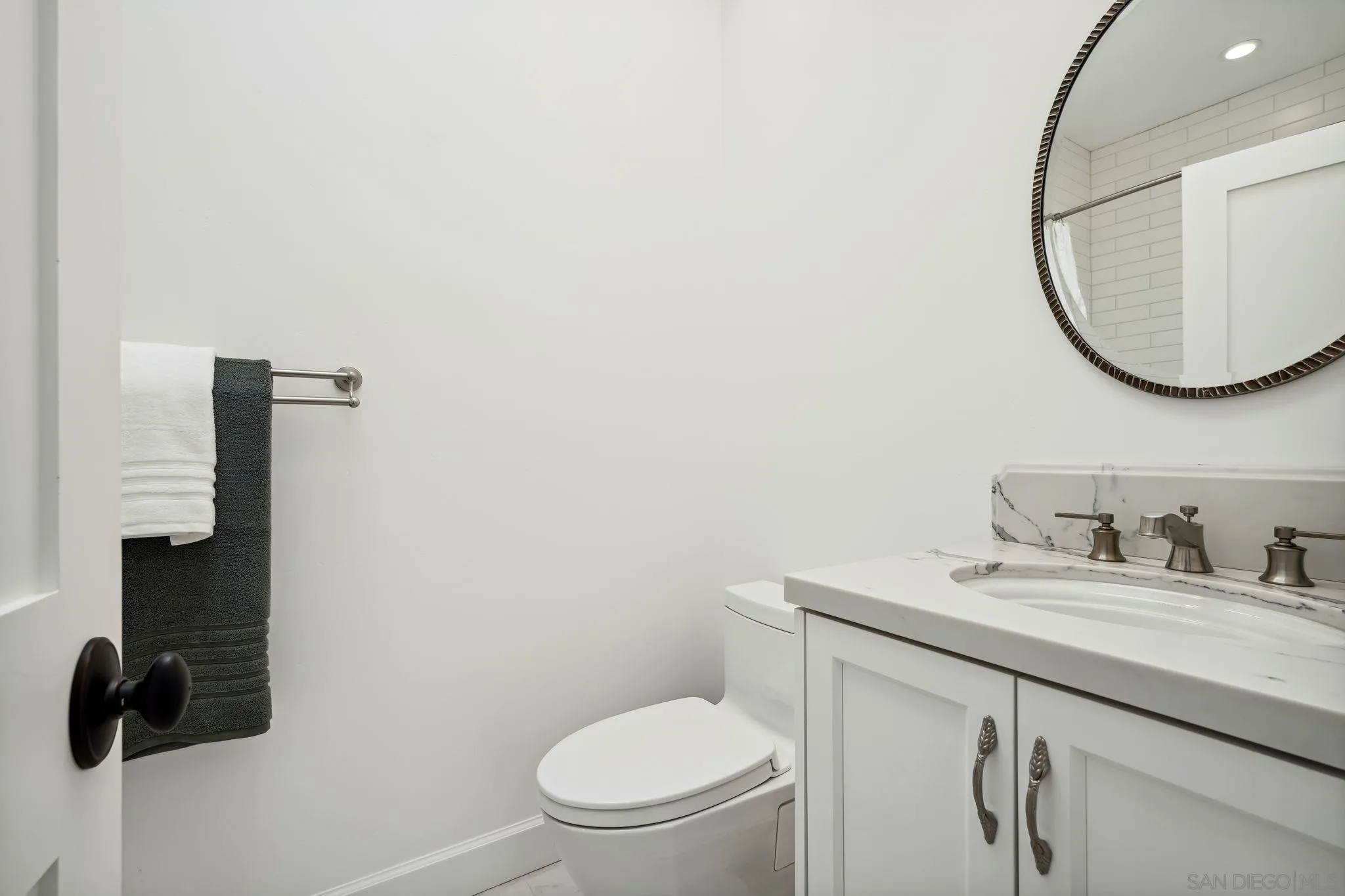 211 Via Osuna Rancho Santa Fe, CA 92091 - Photo 27 of 32 a bathroom with a toilet a sink and mirror
