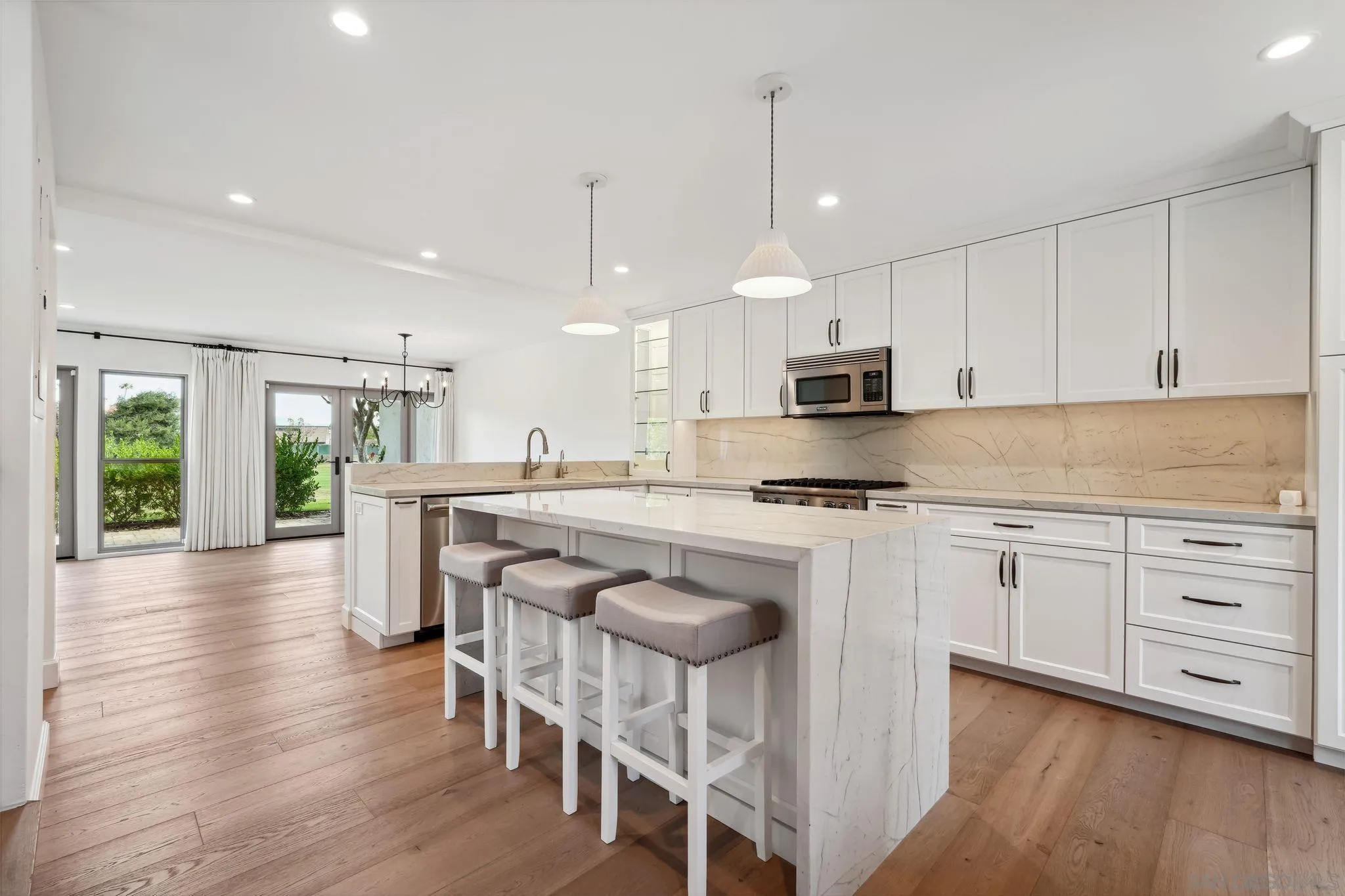 211 Via Osuna Rancho Santa Fe, CA 92091 - Photo 9 of 32 a kitchen with stainless steel appliances granite countertop a stove a sink a microwave a refrigerator and white cabinets with wooden floor