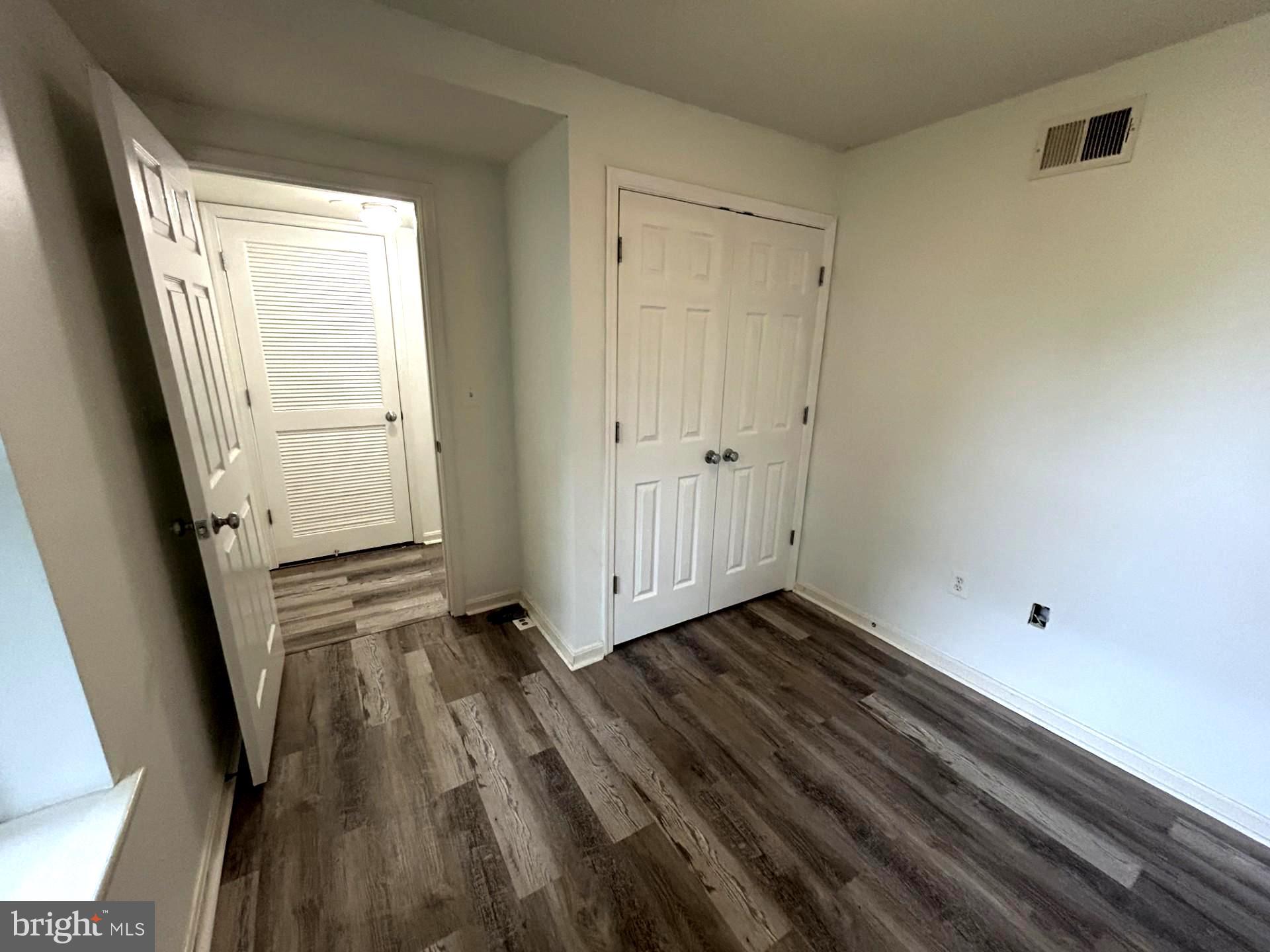 1700 W Street Southeast, Unit 5 Washington, DC 20020 - Photo 8 of 15 a view of an empty room with wooden floor and a window