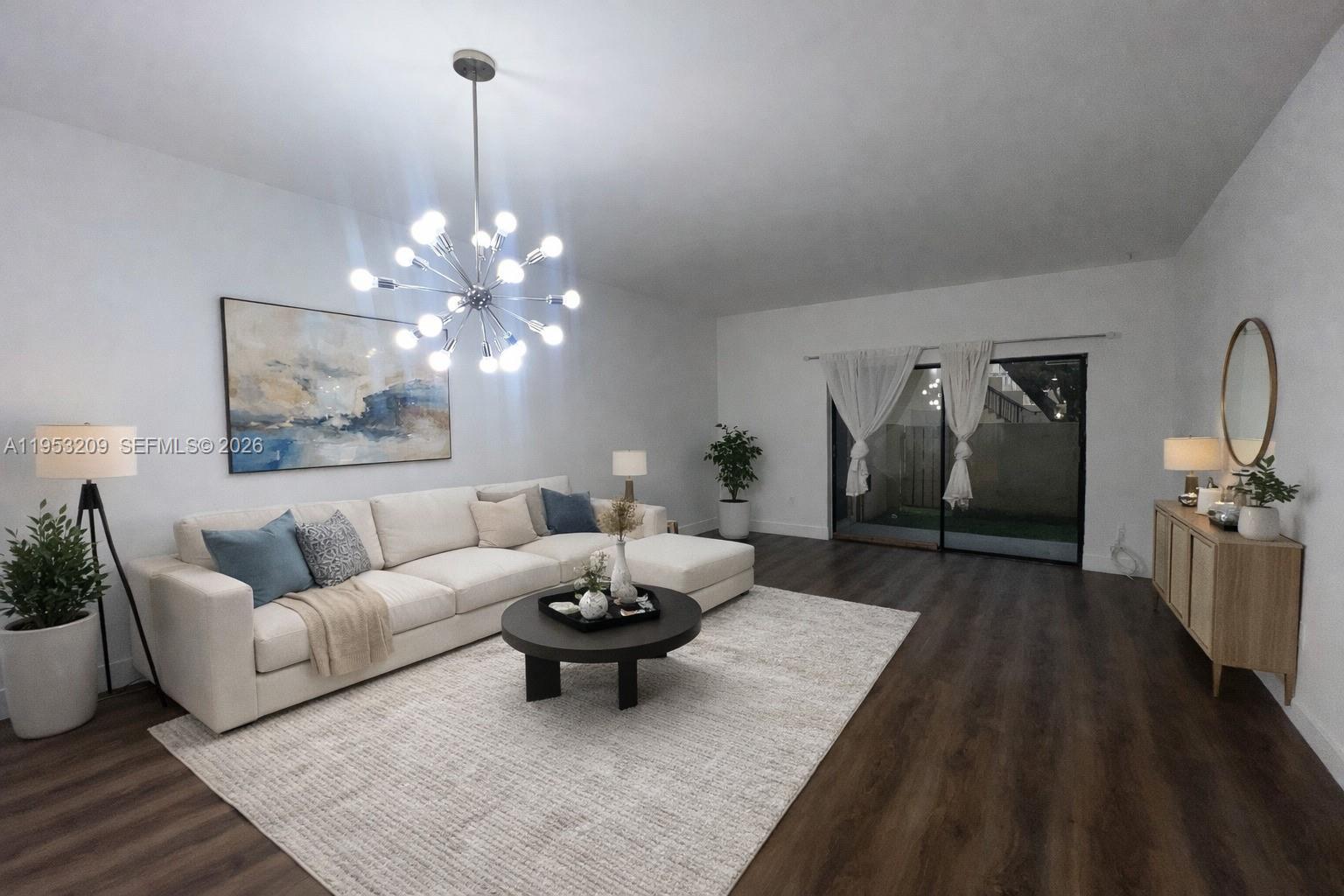 8831 Southwest 130th Place, Unit 106 Miami, FL 33186 - Photo 3 of 15 a living room with furniture and a chandelier