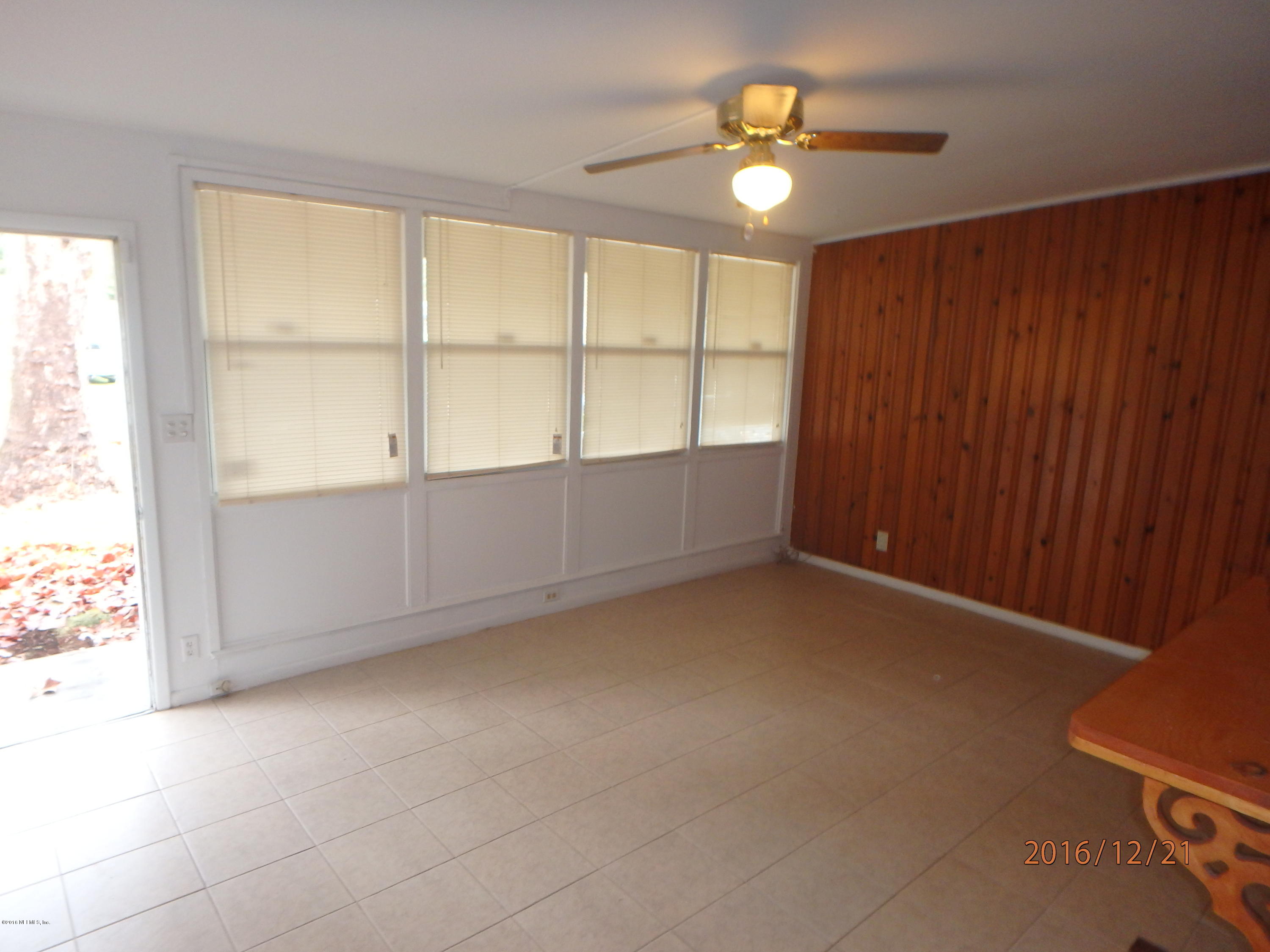 7448 Proxima Road Jacksonville, FL 32210 - Photo 3 of 14 an empty room with chandelier fan and windows