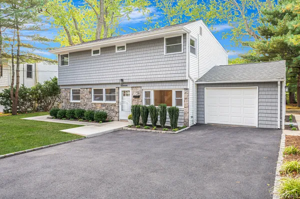 a view of a house with a yard and garage