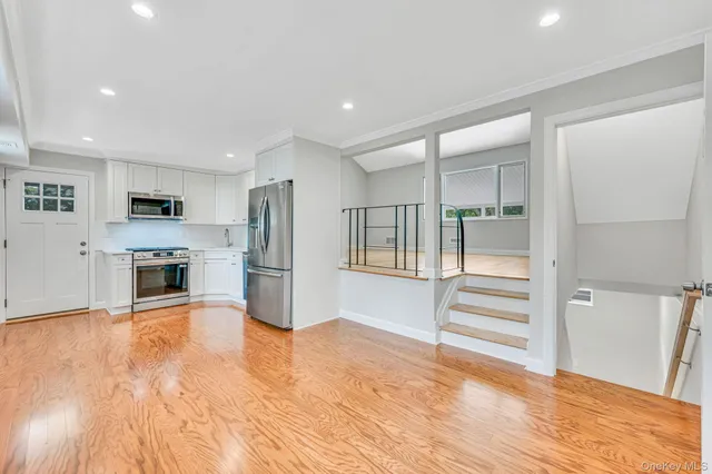 a view of a kitchen with wooden floor and electronic appliances