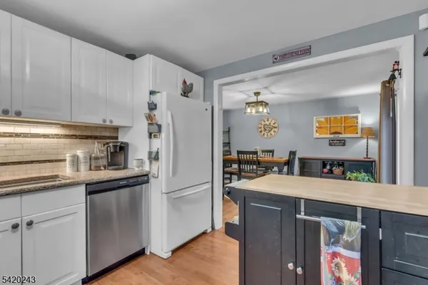 a kitchen with stainless steel appliances white cabinets and a stove top oven