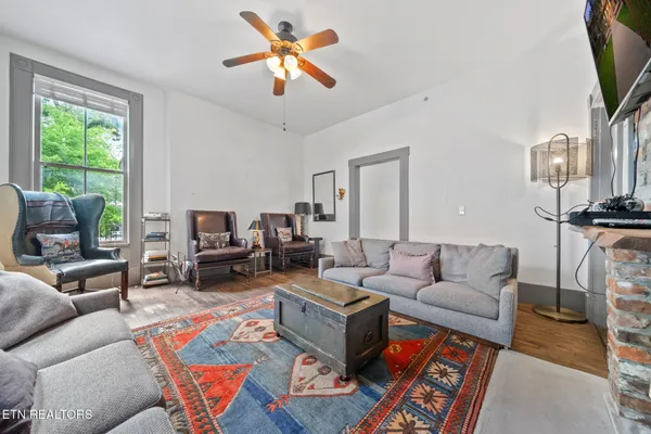 a living room with furniture a flat screen tv and a large window