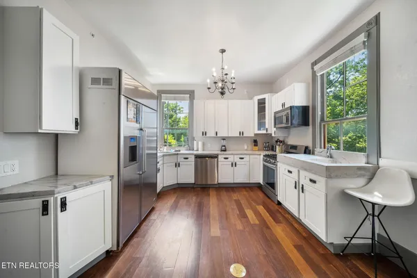 a kitchen with kitchen island a counter top space a sink stainless steel appliances and cabinets