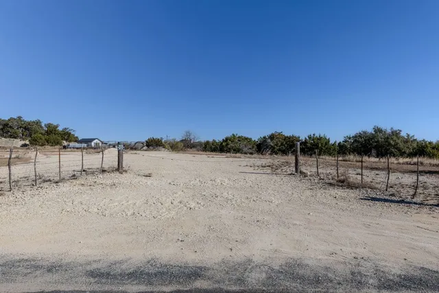 a view of dirt road with a building in the background