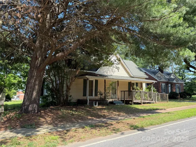 a view of a yard in front of a house with large tree