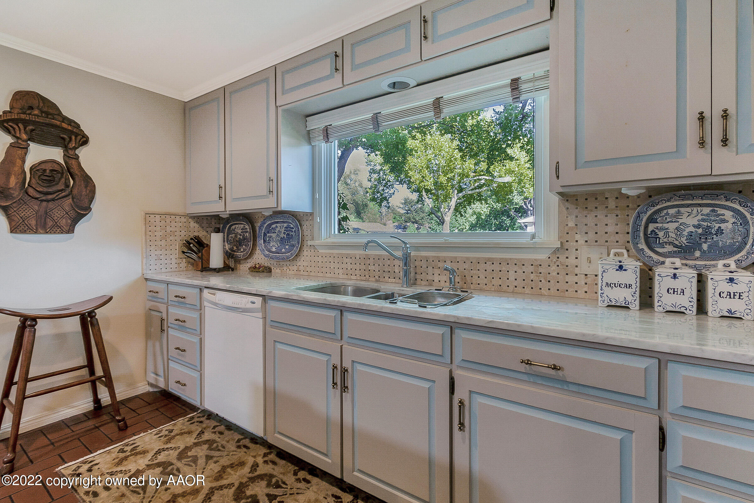 1601 South Austin Street Amarillo, TX 79102 - Photo 15 of 46 a kitchen with stainless steel appliances a sink a stove and white cabinets next to a window