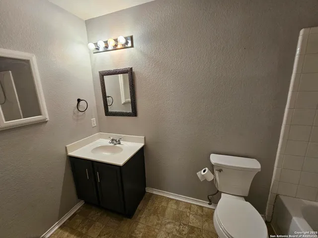 a bathroom with a toilet sink and mirror