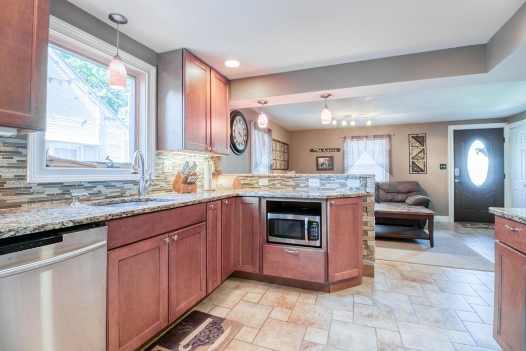 146 Powell Avenue Springfield, MA 01118 - Photo 4 of 22 a kitchen with stainless steel appliances granite countertop a stove a sink and a microwave