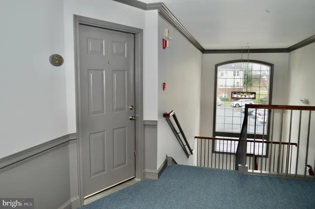 a view of a hallway with wooden floor and stairs
