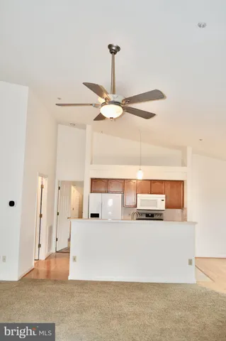 a living room with kitchen island granite countertop furniture and a ceiling fan
