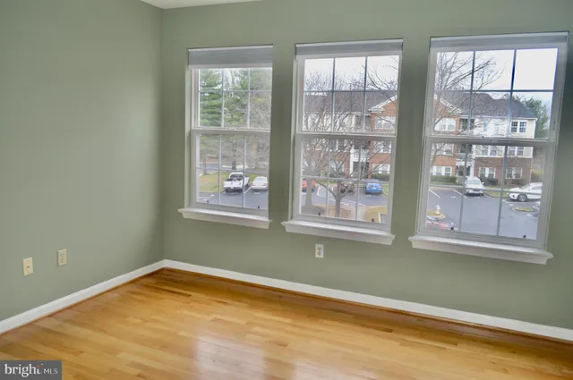 a view of a room with wooden floor and windows