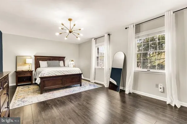 a spacious bedroom with a bed and a chandelier