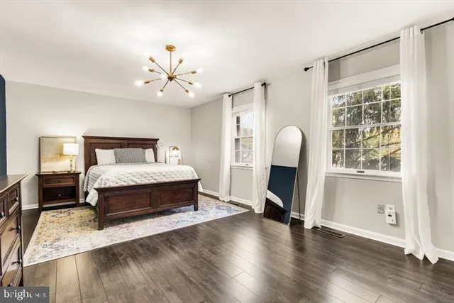 a spacious bedroom with a bed and a chandelier