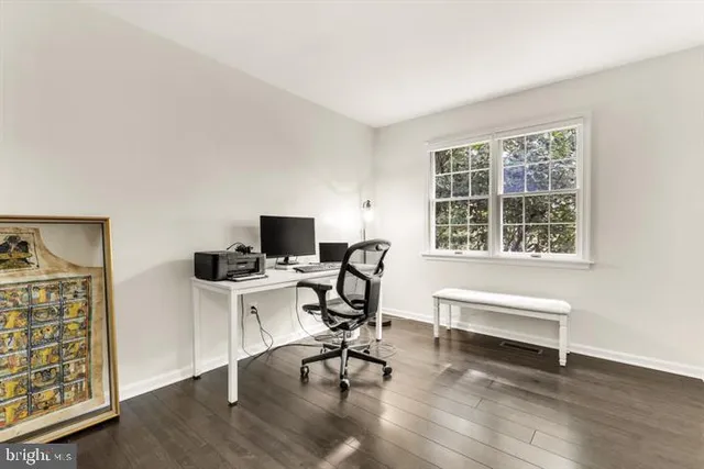 a view of a workspace with furniture and a window