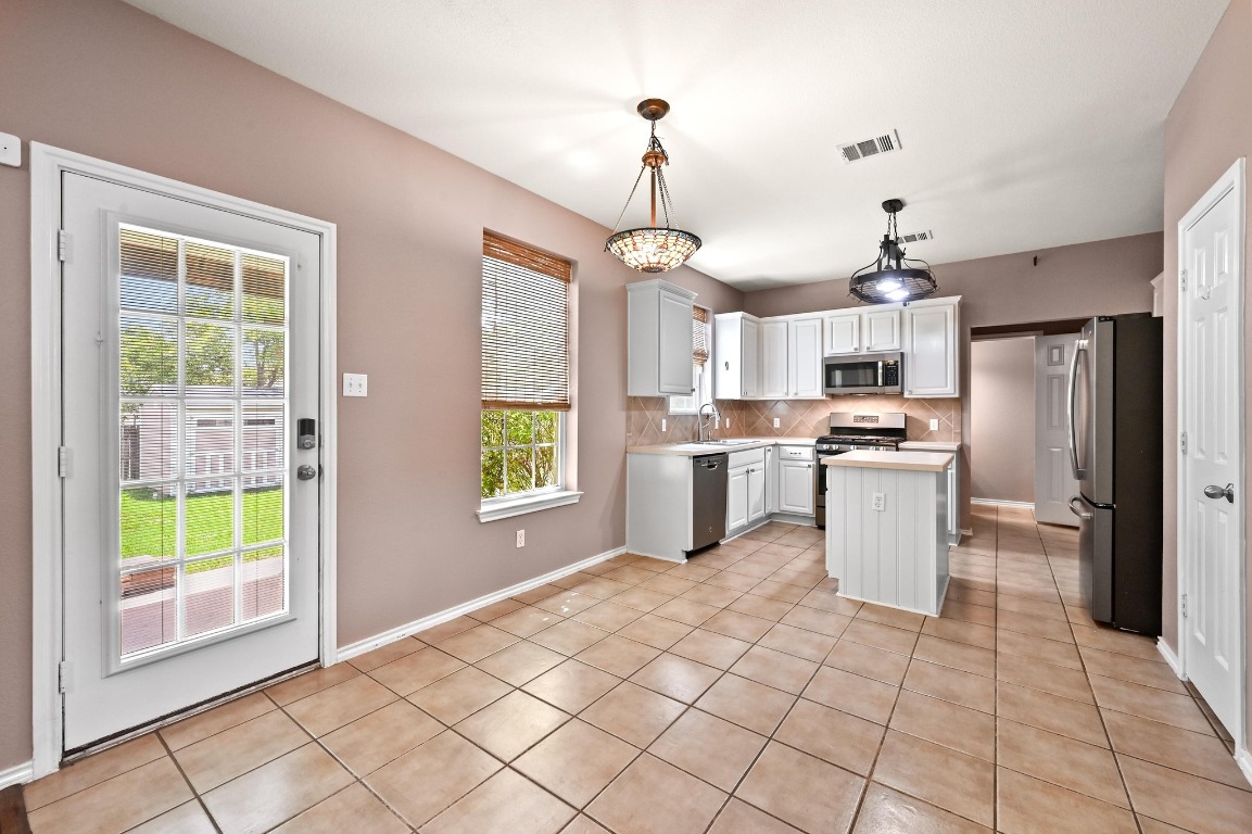 964 Hometown Parkway Kyle, TX 78640 - Photo 12 of 38 a kitchen with white cabinets and refrigerator