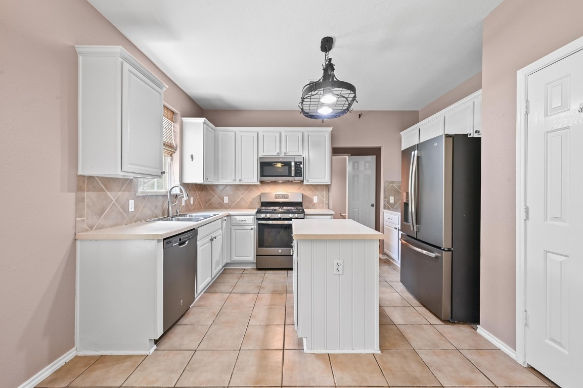 964 Hometown Parkway Kyle, TX 78640 - Photo 13 of 38 a kitchen with a refrigerator a sink and dishwasher