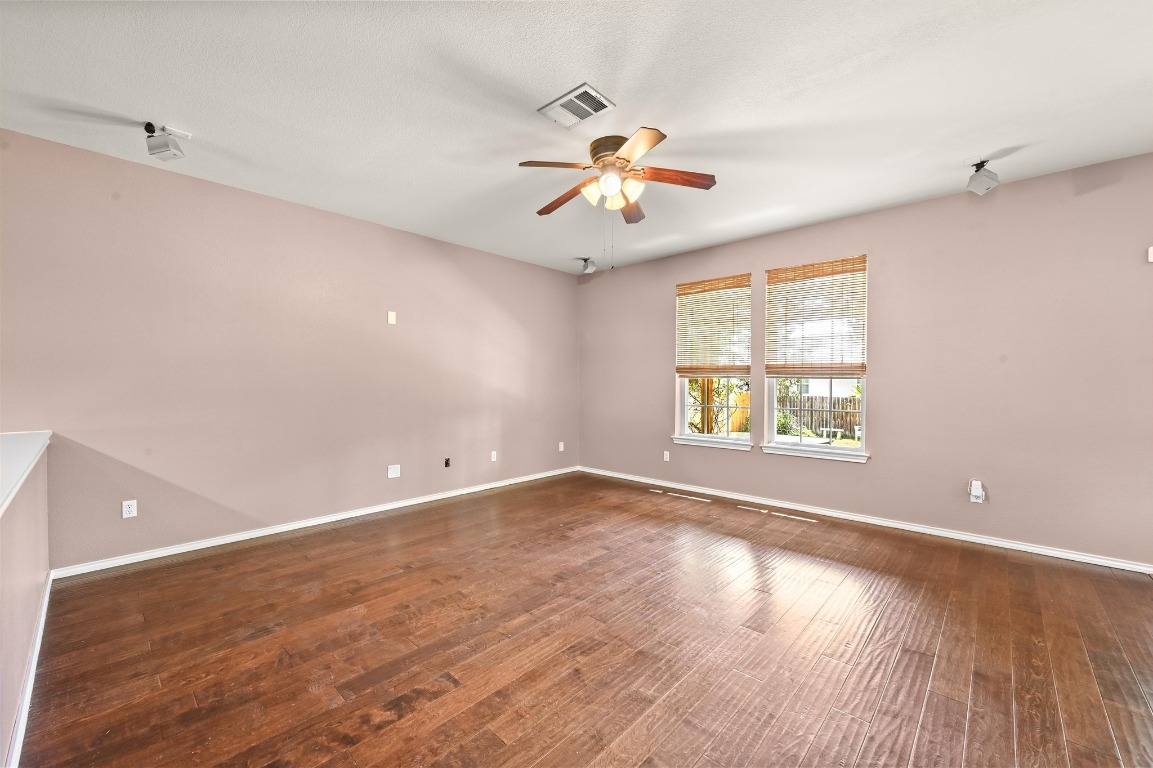 964 Hometown Parkway Kyle, TX 78640 - Photo 9 of 38 an empty room with wooden floor and windows