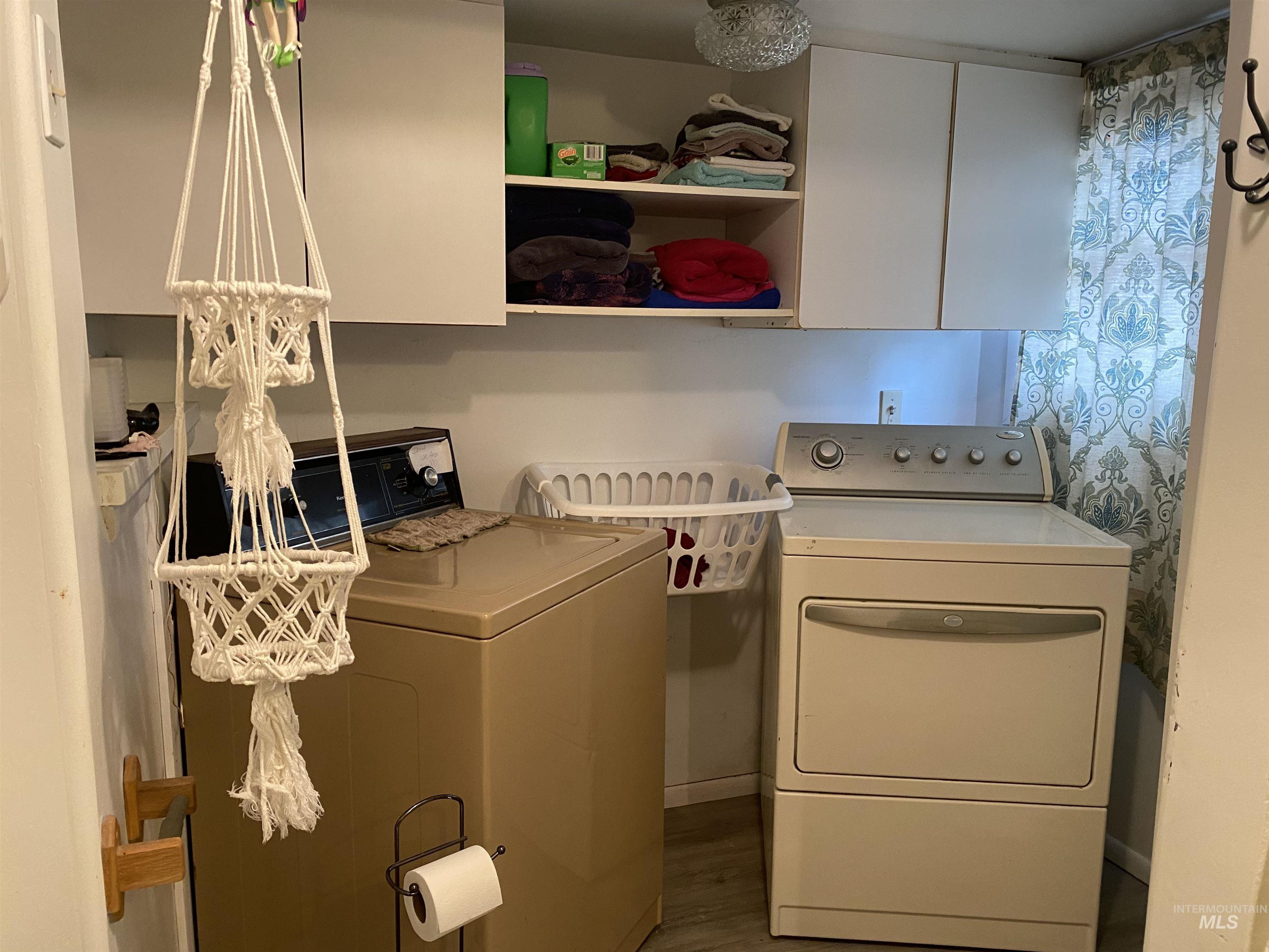 502 East Court Street Weiser, ID 83672 - Photo 12 of 17 Laundry room featuring washing machine and dryer, wood finished floors, and cabinet space