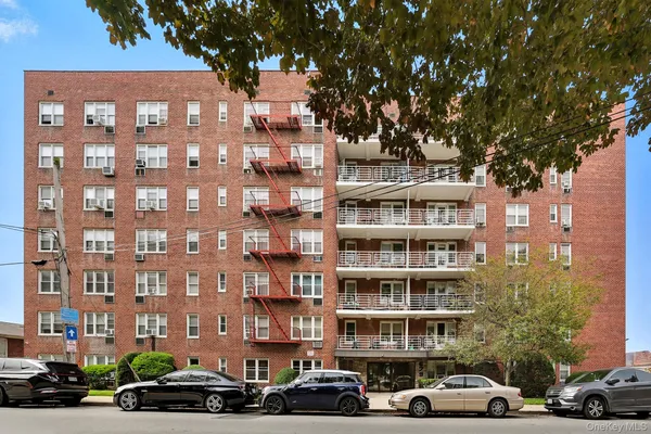 a front view of a building with lot of cars parked