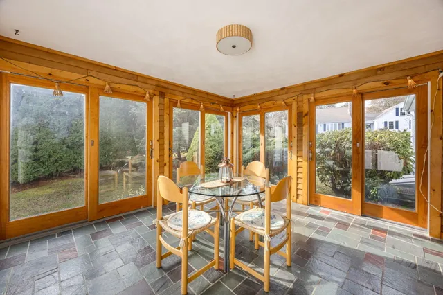 a view of a dining room with furniture and large windows