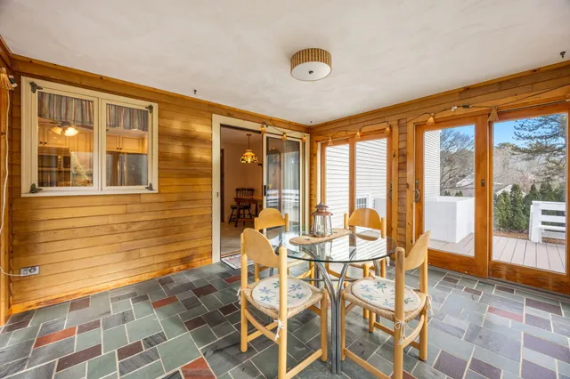 a dining room with furniture and large windows