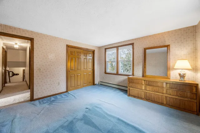 a view of an empty room with window and cabinet