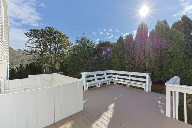 a view of a roof deck with table and chairs a barbeque with wooden floor and fence