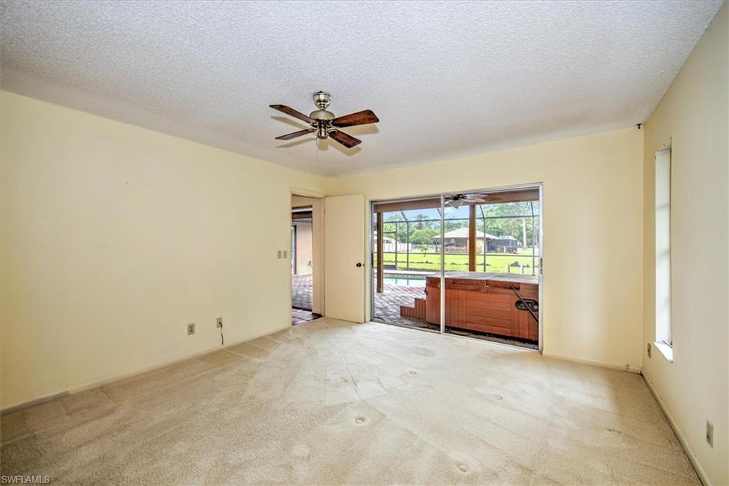 5960 Copper Leaf Lane Naples, FL 34116 - Photo 14 of 37 a big room with windows and a ceiling fan