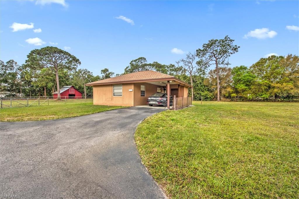 5960 Copper Leaf Lane Naples, FL 34116 - Photo 28 of 37 a front view of a house with a garden and yard