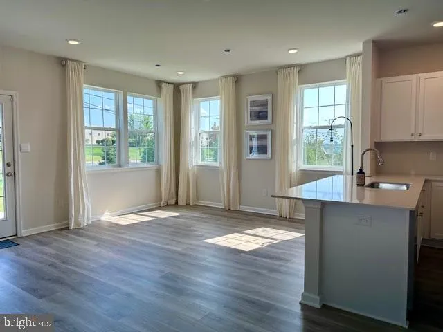 a view of a kitchen with wooden floor and a window