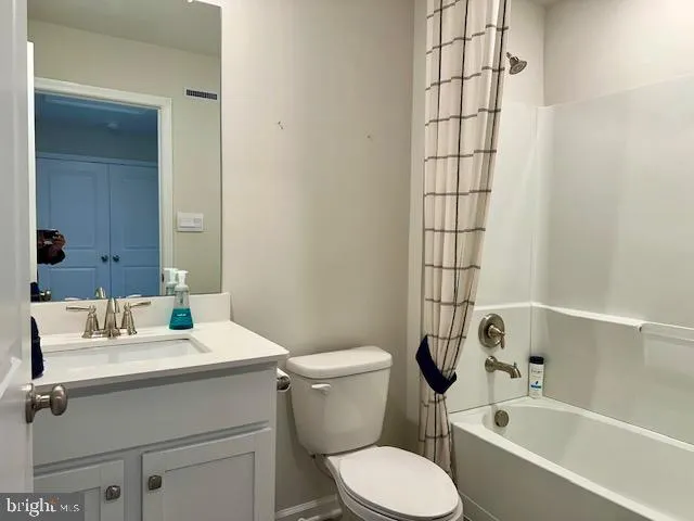 a view of an empty room with closet and a bathroom