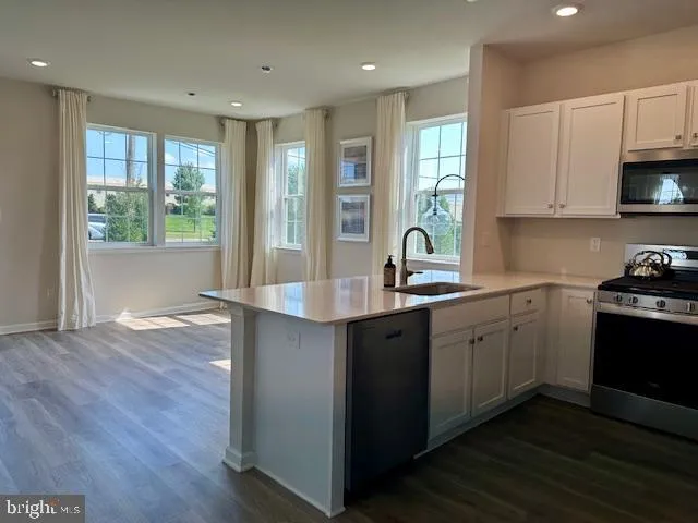 a kitchen with stainless steel appliances granite countertop a sink stove and wooden cabinets