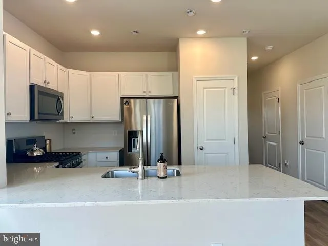 a kitchen with stainless steel appliances granite countertop a refrigerator and a stove top oven