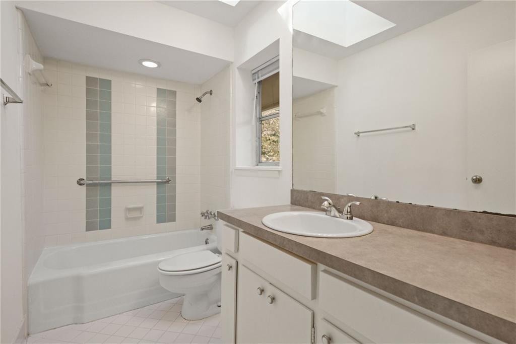 705 Edgewater Trail Sandy Springs, GA 30328 - Photo 29 of 36 a bathroom with a granite countertop sink toilet a mirror and shower